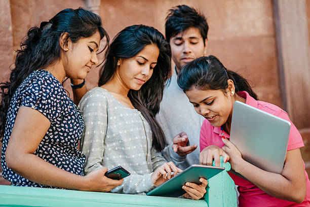 Pretty Smiling Young Indian Students with Laptop and tablet computer Looking at Camera